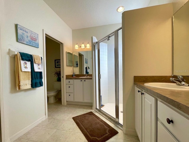 bathroom featuring an enclosed shower, vanity, a textured ceiling, and toilet