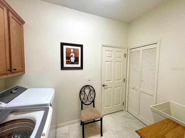 clothes washing area with cabinets and independent washer and dryer