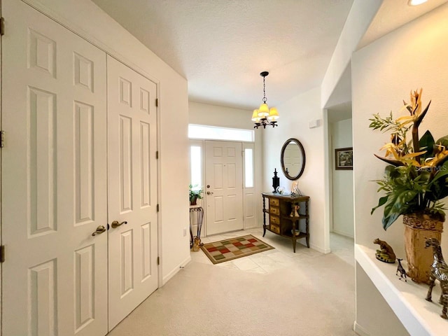 entrance foyer featuring light carpet and a chandelier