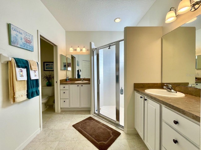 bathroom featuring vanity, walk in shower, toilet, tile patterned floors, and a textured ceiling