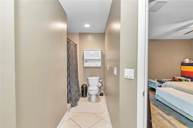 bathroom with tile floors, ceiling fan, and toilet