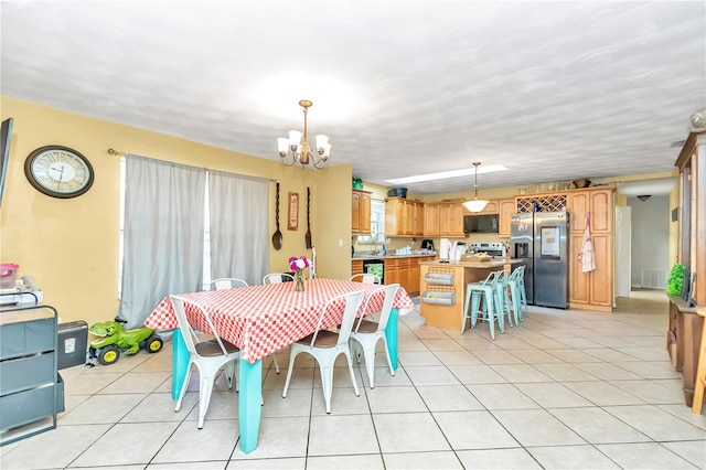 tiled dining space featuring a chandelier