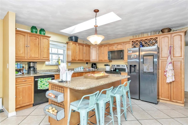 kitchen with a skylight, light tile flooring, black appliances, decorative light fixtures, and a center island