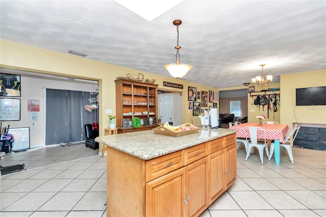 kitchen with a chandelier, pendant lighting, light tile floors, and a center island