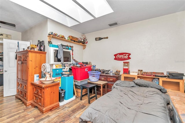 bedroom with dark wood-type flooring and a skylight