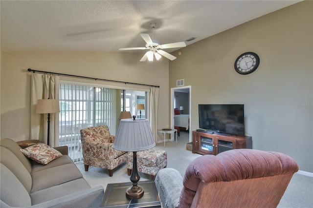 carpeted living room with lofted ceiling, ceiling fan, and a textured ceiling