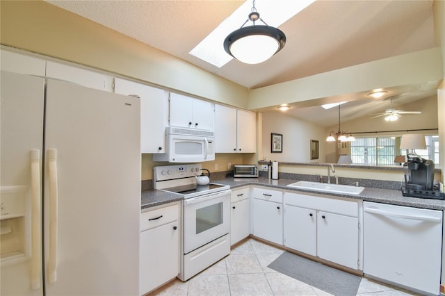 kitchen with white appliances, white cabinetry, hanging light fixtures, and ceiling fan with notable chandelier