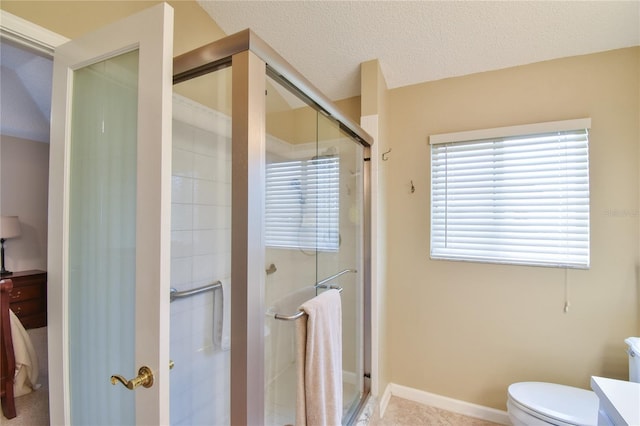 bathroom with vanity, tile floors, a shower with door, a textured ceiling, and toilet