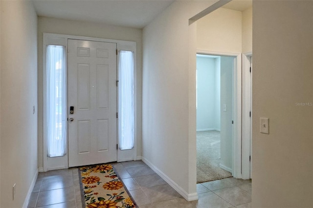 foyer with plenty of natural light and light tile floors