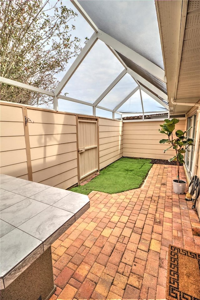 view of patio featuring a lanai