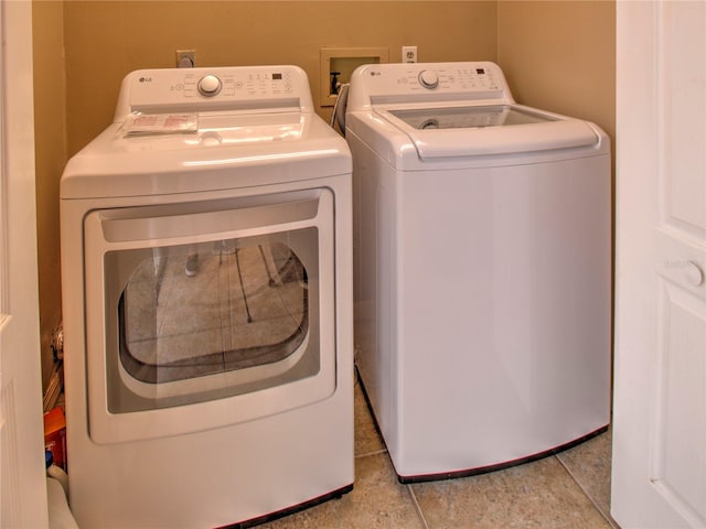 washroom with independent washer and dryer and light tile patterned floors