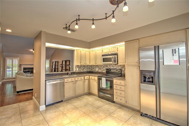 kitchen with light hardwood / wood-style flooring, tasteful backsplash, stainless steel appliances, sink, and ceiling fan