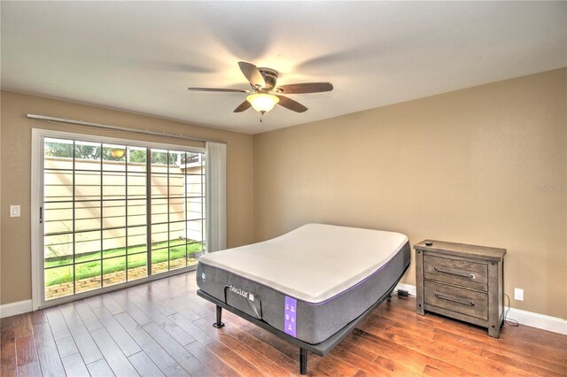 bedroom featuring hardwood / wood-style flooring, ceiling fan, and access to outside