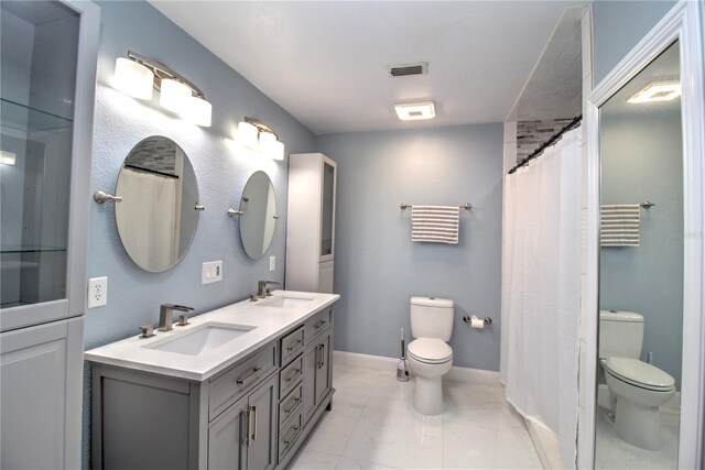 bathroom featuring vanity, toilet, and curtained shower