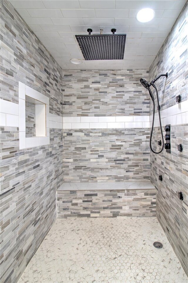 bathroom with tile walls and a tile shower