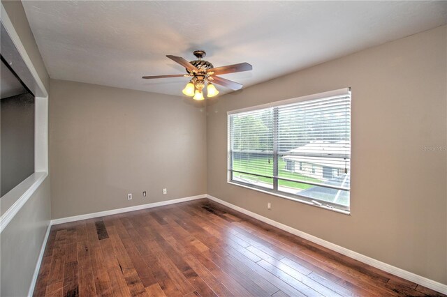 spare room with ceiling fan and dark hardwood / wood-style floors