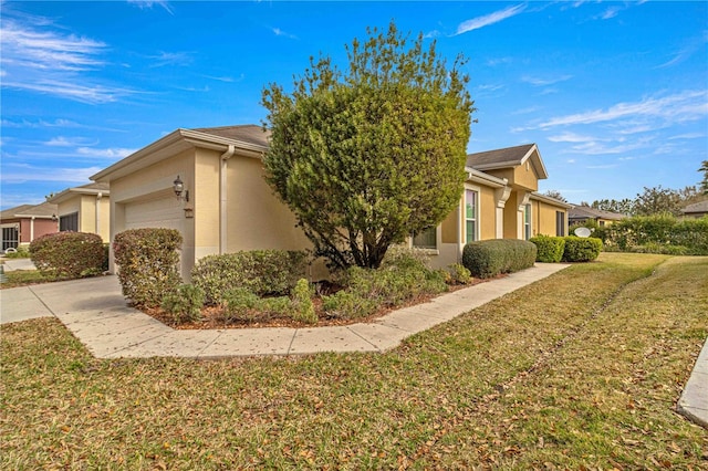 view of side of property featuring a garage and a lawn