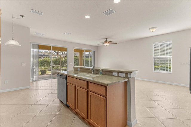 kitchen with a center island with sink, sink, pendant lighting, stainless steel dishwasher, and light tile patterned flooring