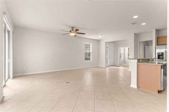 kitchen with a kitchen island with sink, light tile patterned floors, and ceiling fan