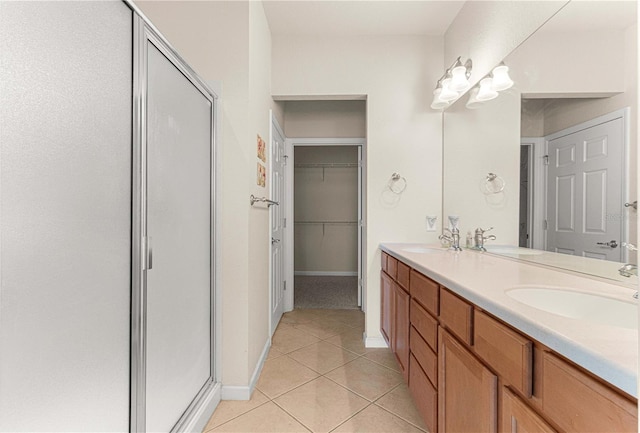 bathroom with tile patterned flooring, a shower with door, and dual bowl vanity