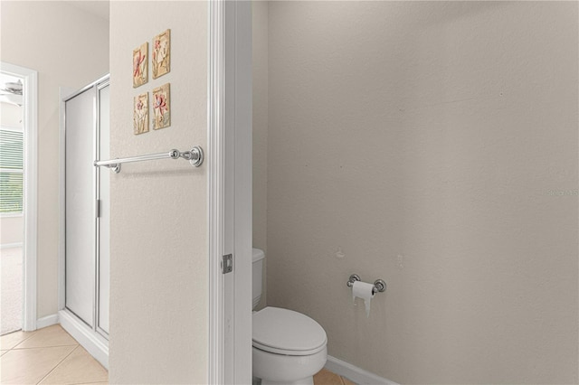 bathroom with a shower with shower door, toilet, and tile patterned flooring