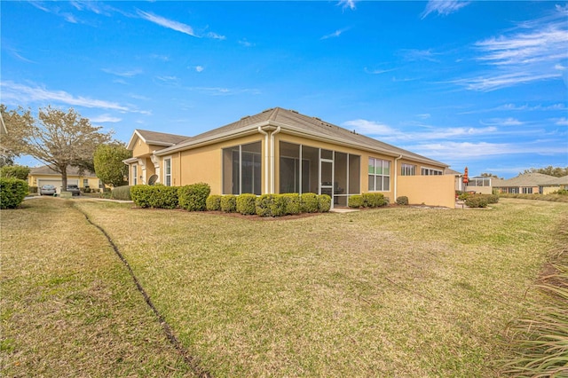 rear view of property with a sunroom and a yard