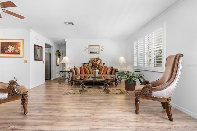 sitting room featuring crown molding, ceiling fan, and light wood-type flooring