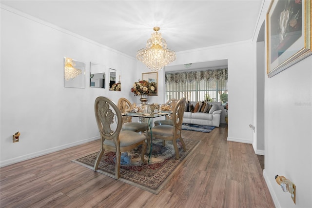 dining room featuring a chandelier, ornamental molding, and dark wood-type flooring