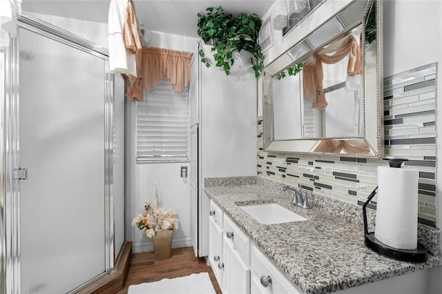 bathroom featuring vanity, backsplash, hardwood / wood-style floors, and walk in shower