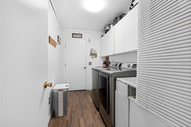 clothes washing area featuring crown molding, cabinets, washer and dryer, and dark wood-type flooring