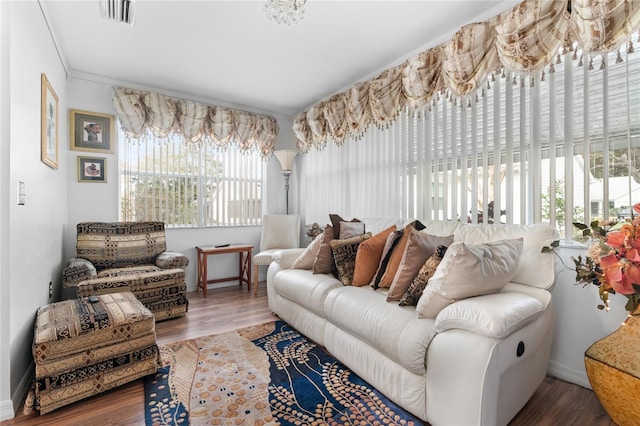 living room with a chandelier, dark hardwood / wood-style floors, and ornamental molding