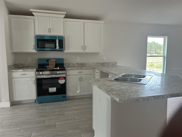 kitchen featuring kitchen peninsula, sink, white cabinets, and appliances with stainless steel finishes