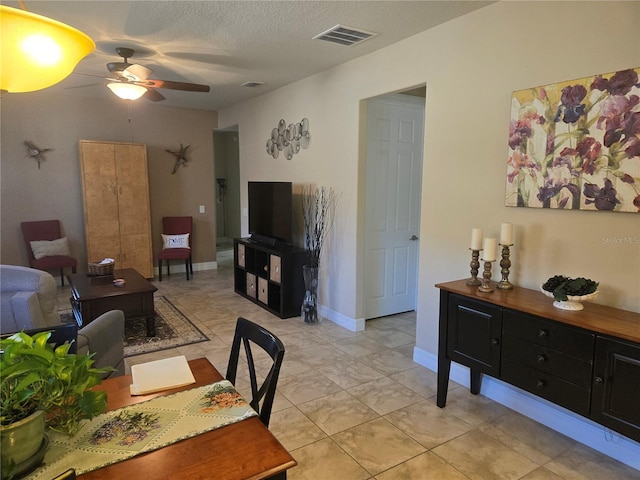 dining room with light tile floors, ceiling fan, and a textured ceiling