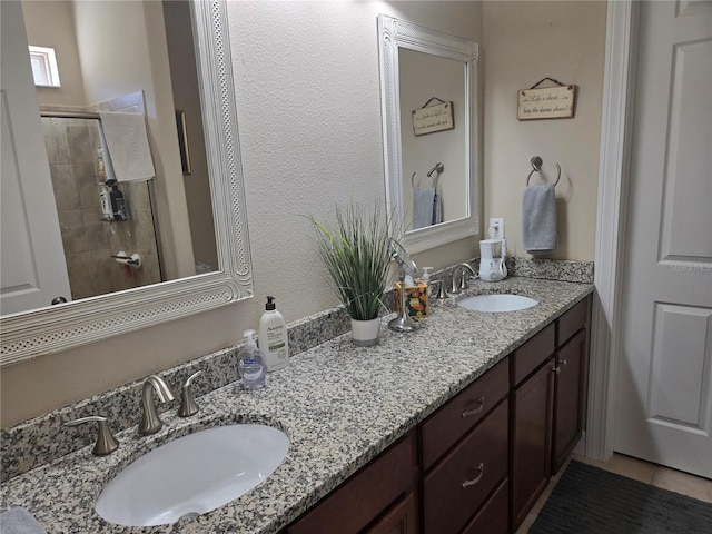 bathroom featuring tiled shower, tile floors, dual sinks, and large vanity