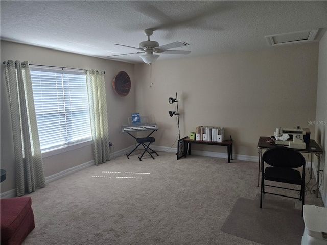 carpeted office space with a textured ceiling and ceiling fan