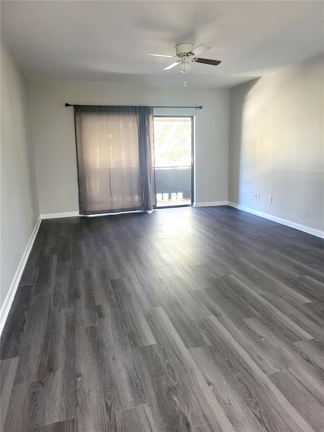 empty room with dark wood-style floors, ceiling fan, and baseboards