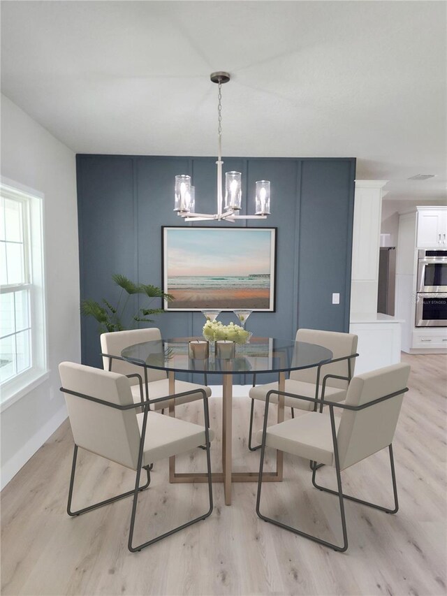 dining space featuring light hardwood / wood-style flooring and a notable chandelier