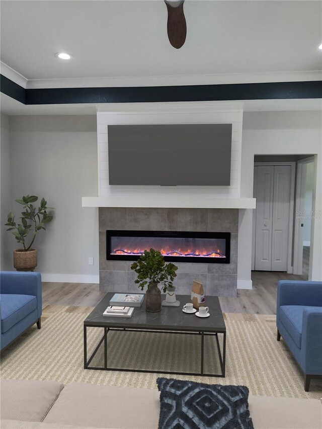 living room featuring a fireplace, ornamental molding, and hardwood / wood-style flooring