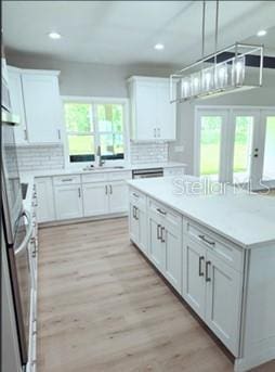 kitchen featuring white cabinets, light wood-type flooring, and plenty of natural light