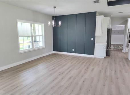 interior space with a chandelier and light hardwood / wood-style floors