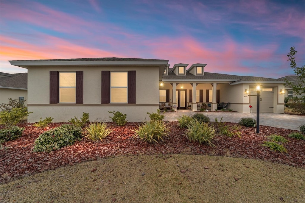 view of front of home with a garage, concrete driveway, and stucco siding