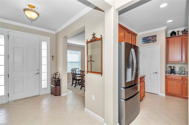 foyer with ornamental molding and light tile floors