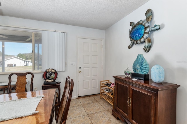 dining space with a textured ceiling and light tile floors