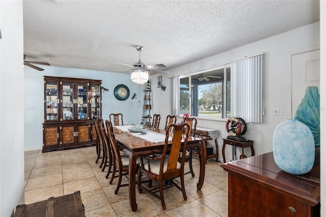 tiled dining space featuring a textured ceiling and ceiling fan