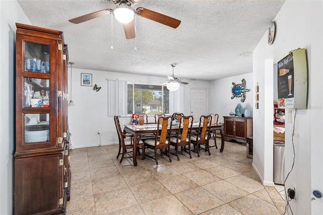 tiled dining space with a textured ceiling and ceiling fan