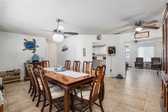 tiled dining space with a textured ceiling and ceiling fan