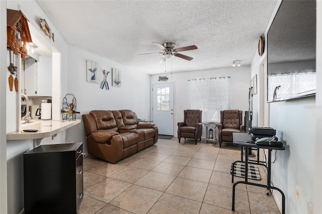 tiled living room with a textured ceiling and ceiling fan