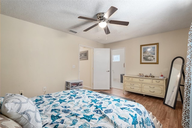 bedroom featuring dark wood-type flooring, a textured ceiling, and ceiling fan