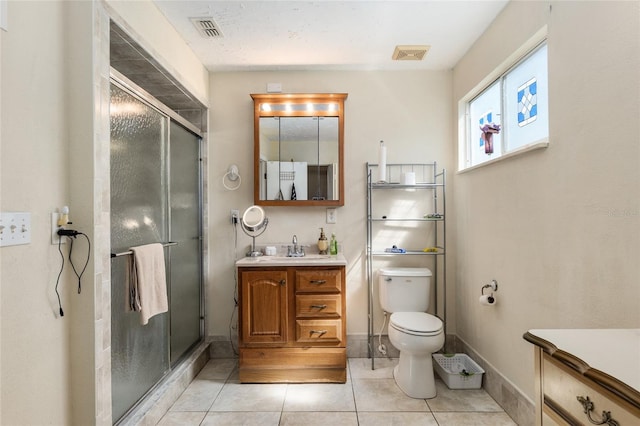 bathroom featuring vanity, tile floors, a shower with shower door, and toilet