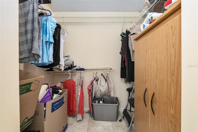 walk in closet with light tile floors